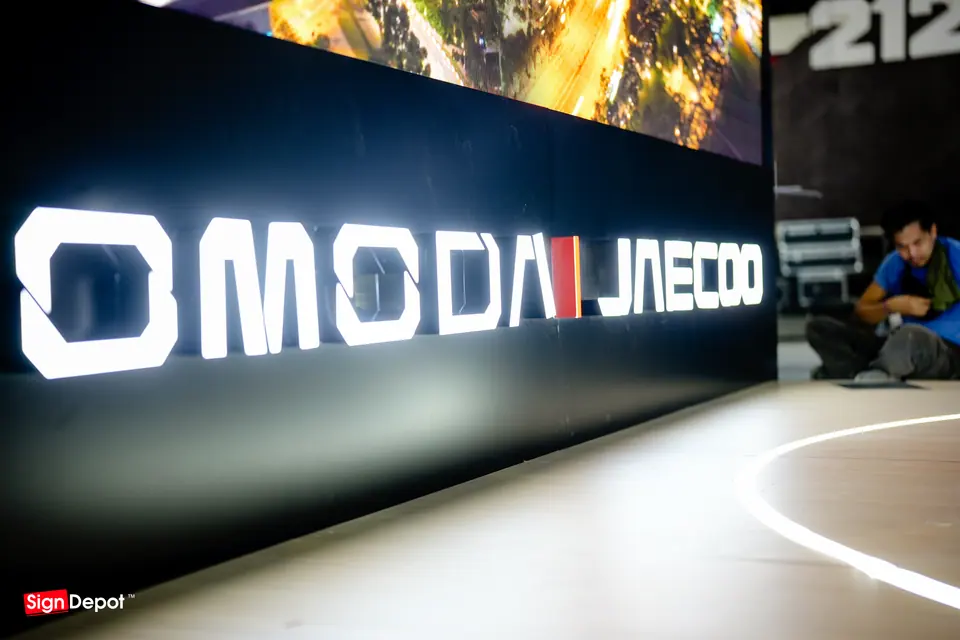 The lit Omoda Jaecoo sign wall