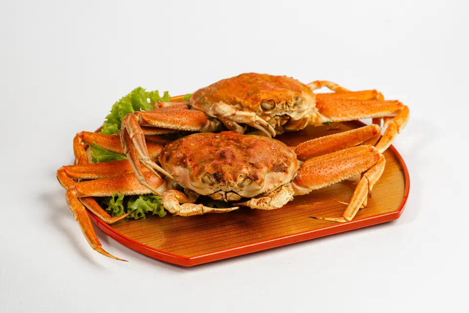 Two crabs on a lacquered tray with lettuce