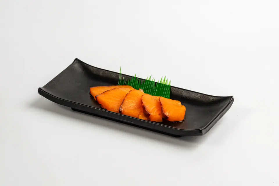 Salmon slices on a black dish