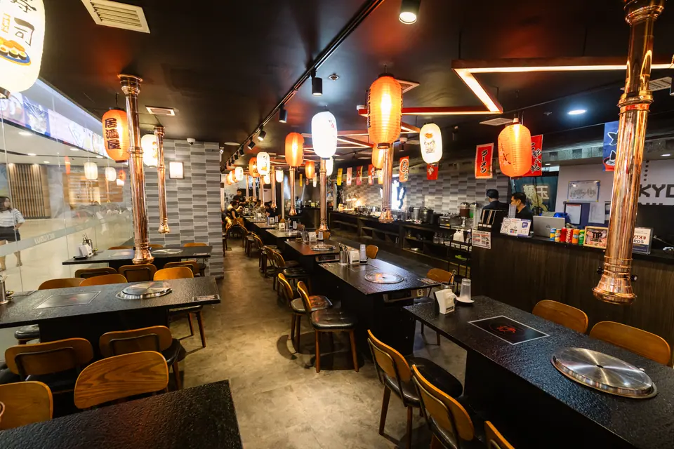The restaurant interior with grill tables and lanterns