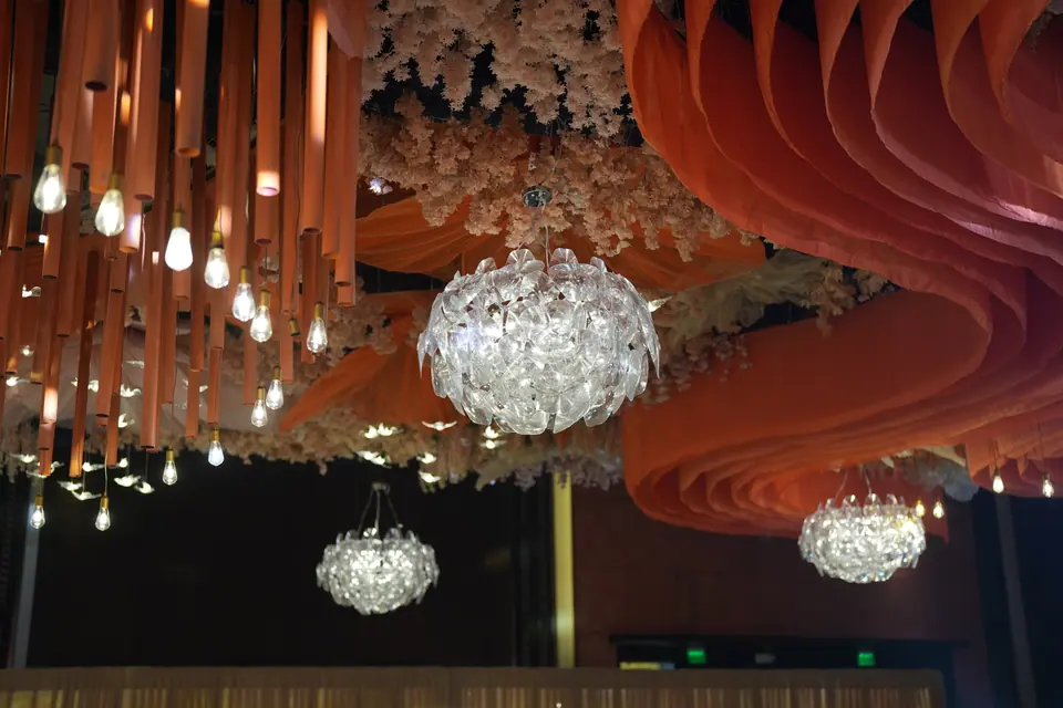 Crystal chandeliers among sculpted orange drapes