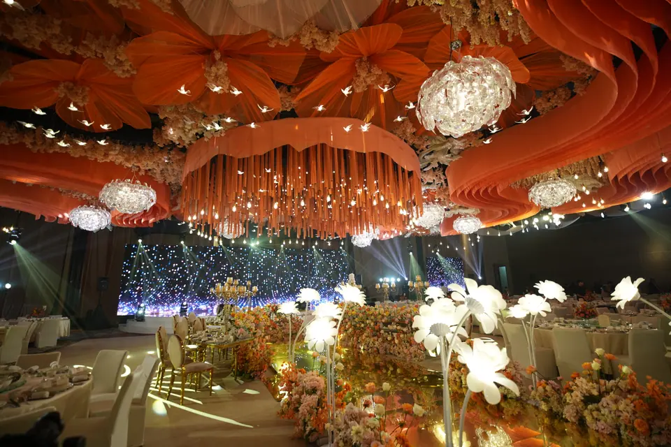 Tables of orange and white flowers under a starlit backdrop