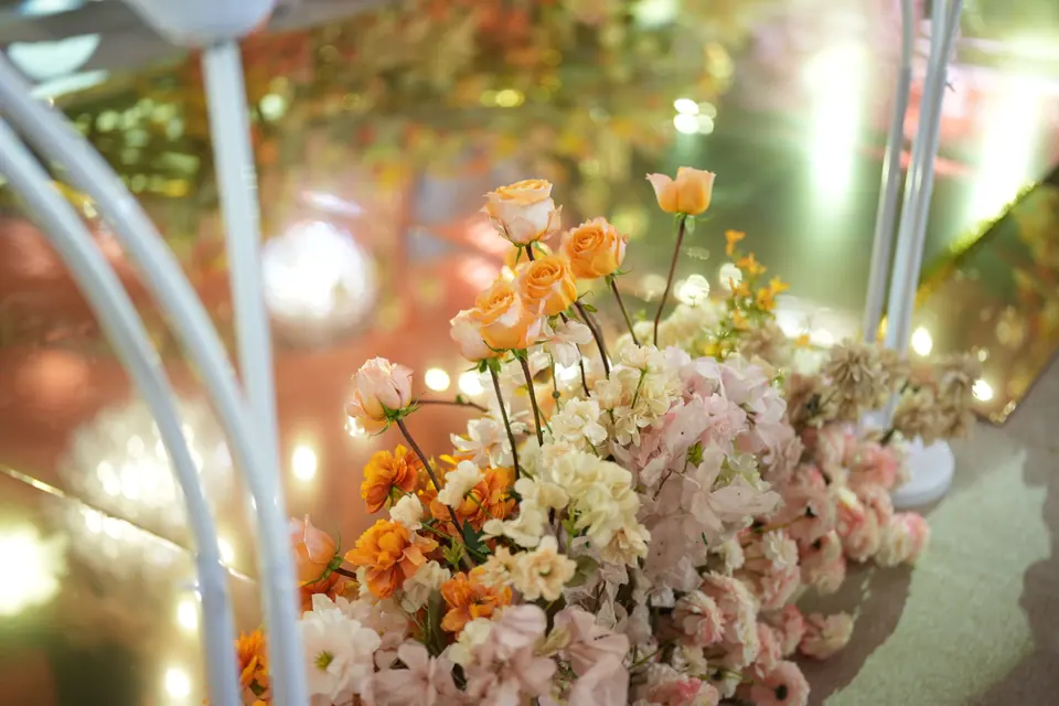 Orange and blush roses in a gilded arrangement